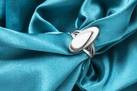 Vintage nacre ring on crumpled blue satin as a backgroundの写真素材