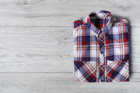 Plaid shirt folded on white wooden backgroundの写真素材