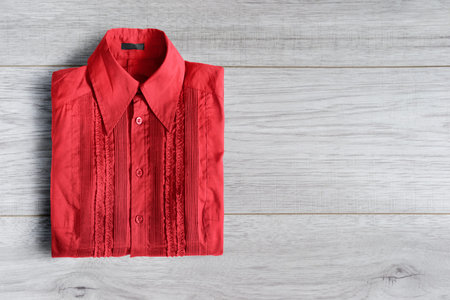 Red blouse folded on white wooden backgroundの写真素材
