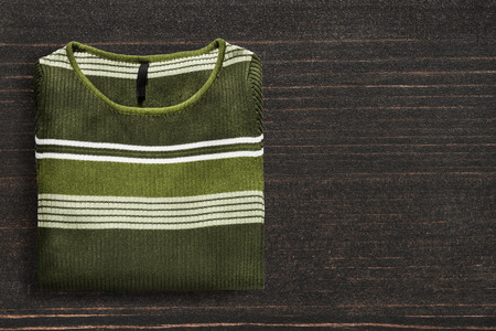 Folded green pullover on dark wooden backgroundの写真素材