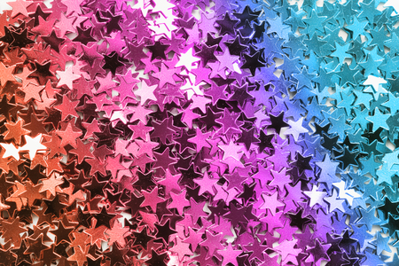 Colorful metallic star shaped confetti as a backgroundの写真素材