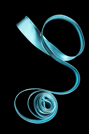Blue satin ribbon on black backgroundの写真素材