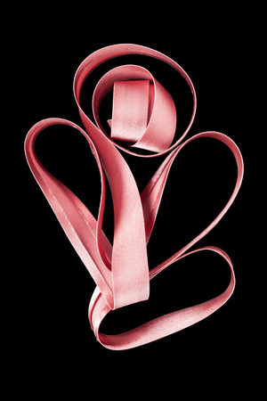 Pink satin ribbon isolated over blackの写真素材