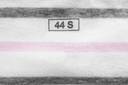 Clothes label on striped cloth as a backgroundの写真素材