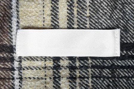 Blank white clothes label on wool cloth as a backgroundの写真素材