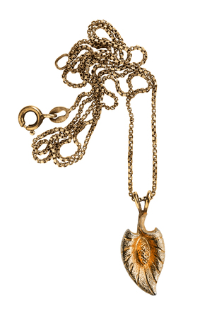 Golden leaf shaped pendant on a chain isolated over whiteの写真素材