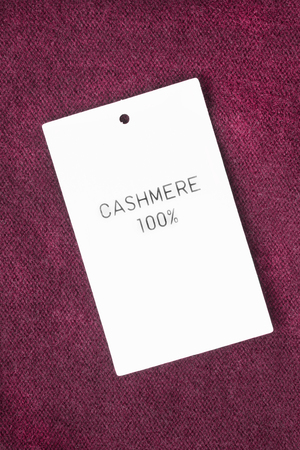 Fabric composition label on maroon cashmere backgroundの写真素材