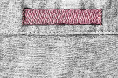 Blank pink clothes label on gray cloth as a backgroundの写真素材