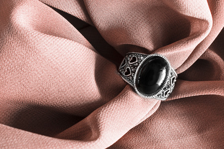 Vintage black onyx ring on crumpled beige silk as a backgroundの写真素材