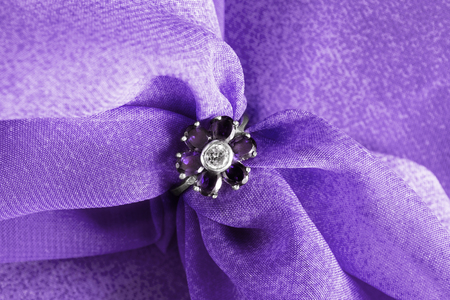 Amethyst flower shaped ring on purple cloth as a backgroundの写真素材
