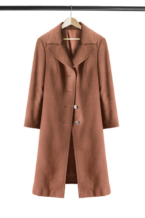 Elegant brown coat on wooden clothes rack isolated over whiteの写真素材