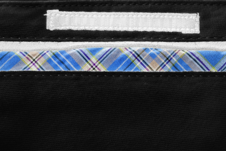 Blank clothes label on black cloth as a backgroundの写真素材