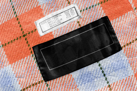 Clothes label on colorful wool tartan as a background