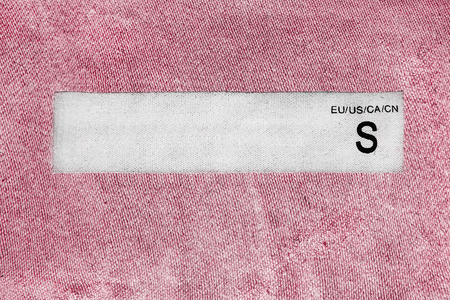 White clothes label on pink cloth as a backgroundの写真素材