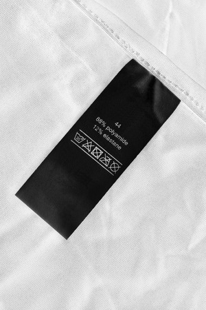 Fabric composition and washing instructions label on white clothの写真素材