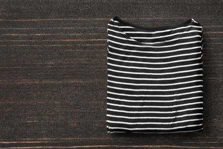 Folded black and white striped top on dark wooden backgroundの写真素材