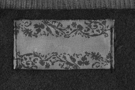 Blank clothes label on black wool as a backgroundの写真素材