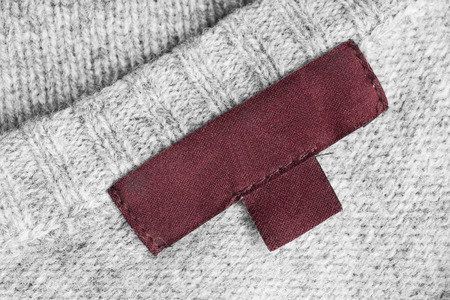 Blank brown clothes label on gray knitted backgroundの写真素材