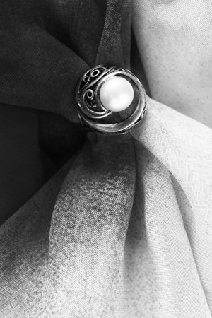 Pearl ring on crumpled black and white cloth as a backgroundの写真素材