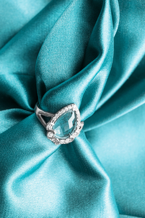 Elegant topaz ring on cyan crumpled satin as a backgroundの写真素材