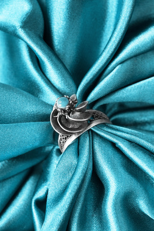 Vintage turquoise ring on draped blue satin as a backgroundの写真素材