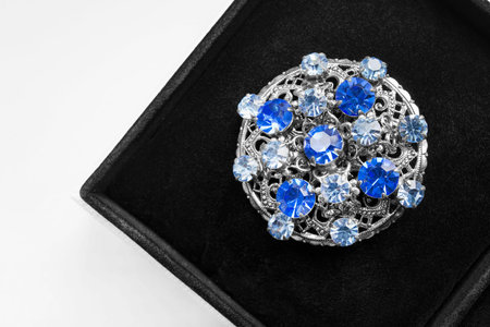 Silver medallion with blue gems in black jewel box closeupの写真素材