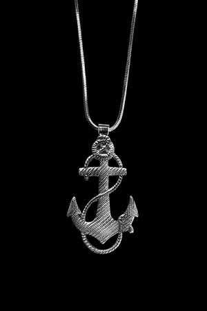 Silver anchor pendant on a chain on black background