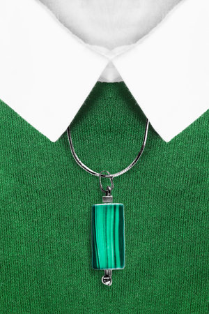 Malachite pendant over green pullover with white collar closeupの写真素材
