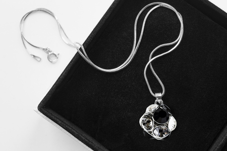 Crystal ball pendant on silver chain in black jewel box closeupの写真素材