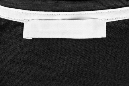 White blank clothes label on black cotton as a background