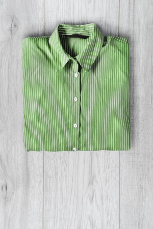 Folded green striped shirt on gray wooden backgroundの写真素材