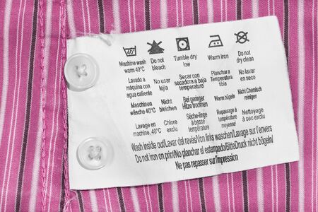 Washing instructions clothes label on pink striped cotton closeupの写真素材