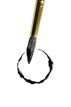 Painting brush drawing black circle on white backgroundの写真素材