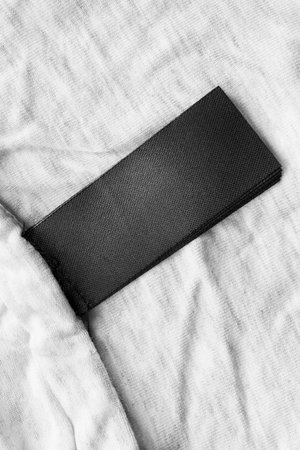 Blank black clothes label on white cotton as a backgroundの写真素材