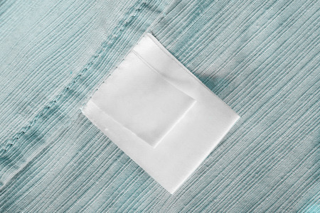 Blank white clothes label on blue cotton as a backgroundの写真素材