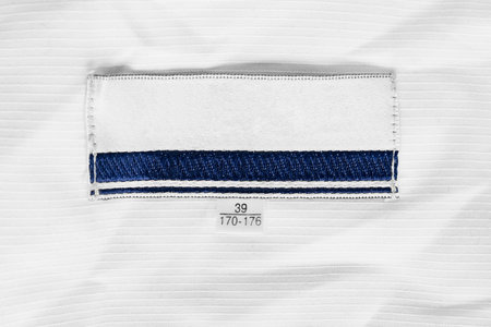 Textile blank clothes label on white cotton closeup as a background
