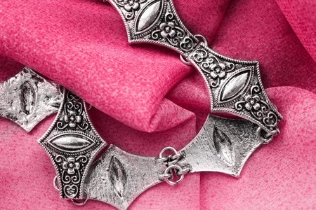 Vintage silver necklace on pink folded silk closeup