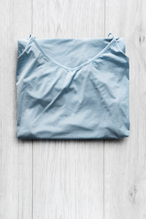 Folded blue silk blouse on white wooden backgroundの写真素材