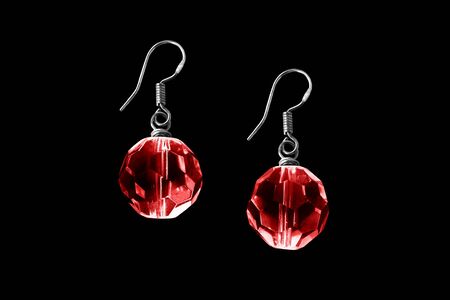 Red crystal balls faceted earrings isolated over blackの写真素材