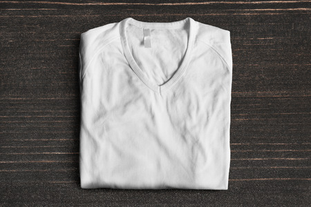 White basic sport t-shirt folded on dark wooden backgroundの写真素材