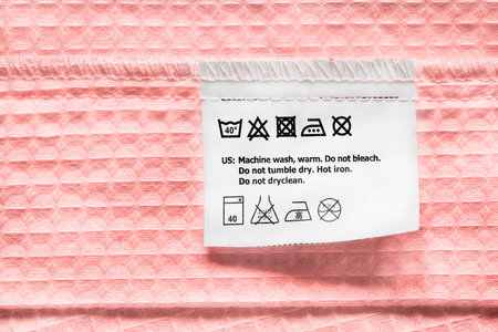 Washing instructions clothes label on pink cotton closeupの写真素材