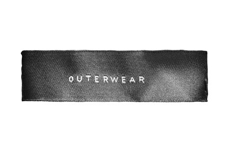 Black textile clothes label lettered outerwear isolated over white
