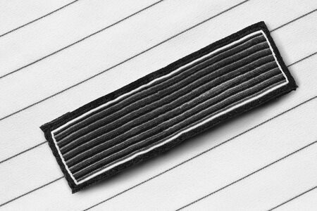 Black blank textile clothes label on striped black and white backgroundの写真素材