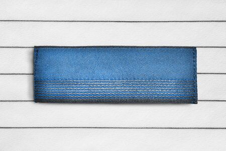 Blank blue clothes label on striped black and white textile backgroundの写真素材