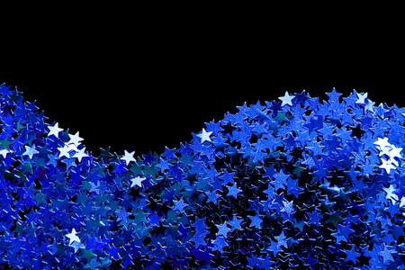Abstract blue star shaped metallic confetti isolated over blackの写真素材