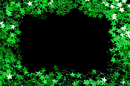Green glitter stars as a frame on black backgroundの写真素材