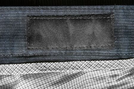 Black blank textile clothes label on textile background closeupの写真素材