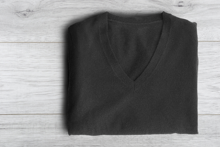 Folded black cashmere sweater on white wooden backgroundの写真素材
