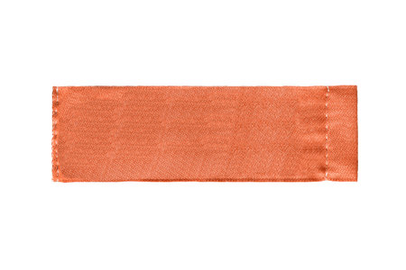 Blank textile orange clothes label on white background