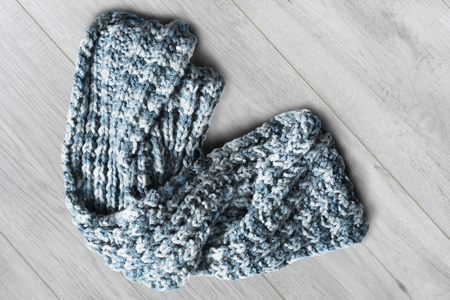 Crumpled blue knitted wool scarf on white wooden backgroundの写真素材